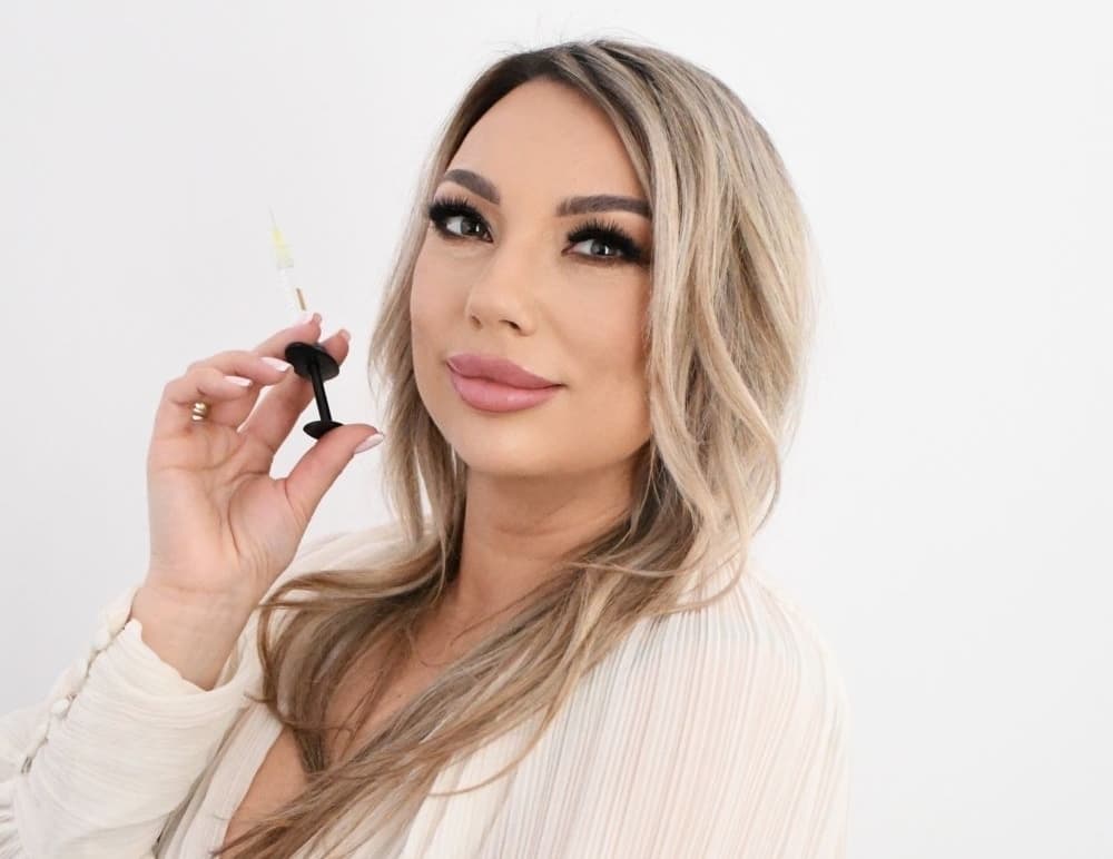 Olga Noszczyk trzymająca ampułko strzykawkę z preparatem do stymulacji skóry.