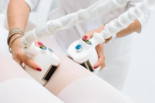 Zabieg antycellulitowy urządzeniem Icoone wykonywany na udach pacjentki.